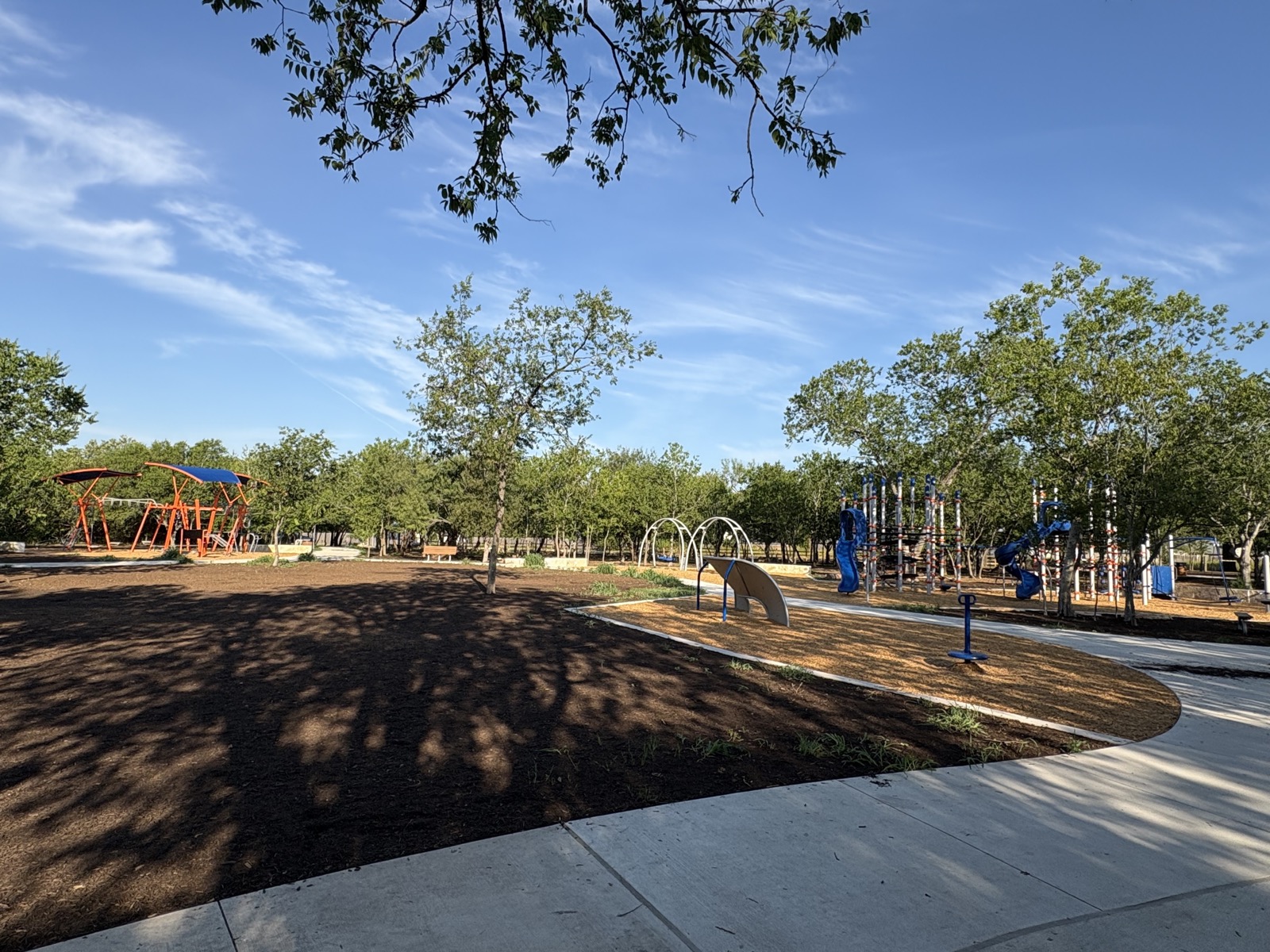 Little Walnut Creek Greenbelt playground surrounded by native trees and natural landscape in East Austin